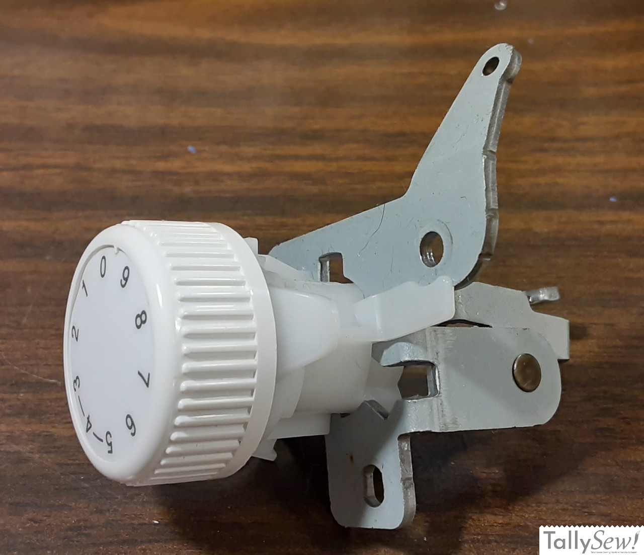 Brother JX2517 tensioner unit connected to its tensioner bracket, both removed from the machine