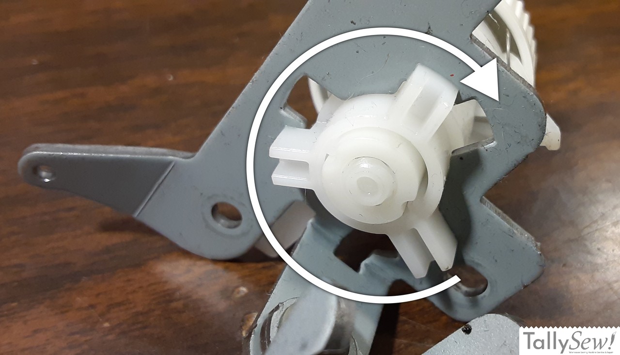 Tensioner bracket from a Brother JX2517 sewing machine with an illustrated arrow showing how to remove the tensioner