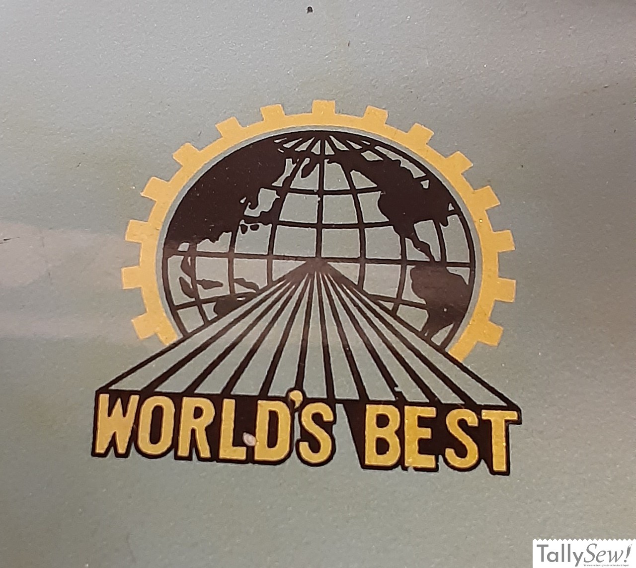 Morse 600 sewing machine Bed Decal Proclaiming "WORLD'S BEST" being projected out of a map of the earth inside a gear pattern.