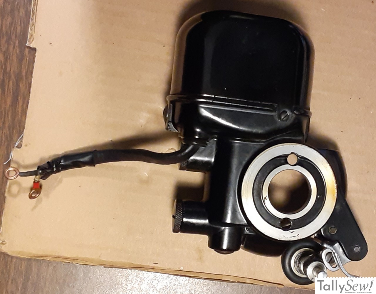 Close-up of the direct-drive 'potted' motor from a Singer 201-2, removed from the machine to show its all-metal, self-contained construction.