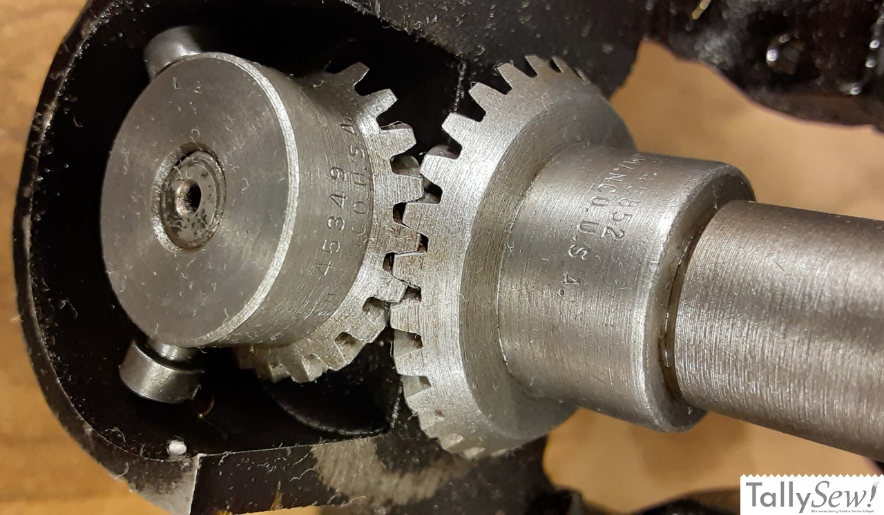 A detailed view of the all-metal internal gears of a Singer 201-2, with the hook drive gear on the left.